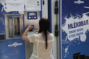 A girl puts money into the machine "Milk-bar"