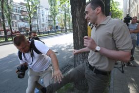 An employee of the Embassy of Georgia beats photojournalist