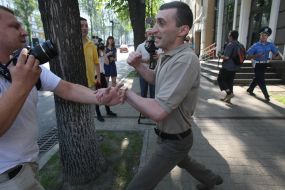 An employee of the Embassy of Georgia beats photojournalist