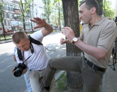 An employee of the Embassy of Georgia beats photojournalist
