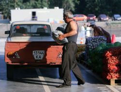 Покупець несе мішок з баклажанами