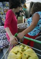 Покупниці везуть візок з овочами