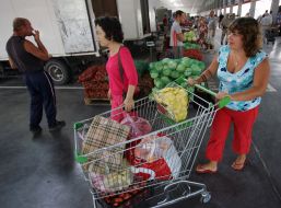 Покупниці везуть візок з овочами