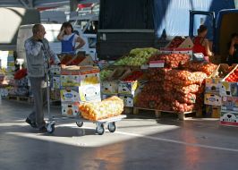 Покупець везе візок з овочами