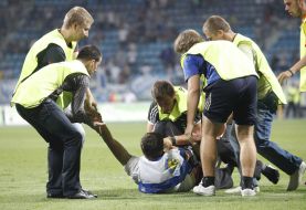 Stewards of the stadium detain a fan