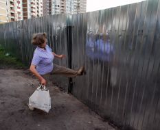 A woman tries to bring down a fence