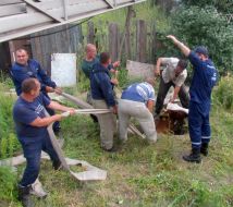 The rescuers of the Ministry of Emergency Measures try to pull a cow out from a technical pit