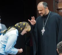 Священник благословляет прихожанку