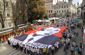 Участники шествия несут флаг с изображением Бандеры