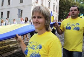 Участники шествия несут Государственный флаг Украины