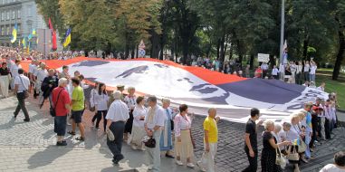 Участники шествия несут флаг с изображением Бандеры