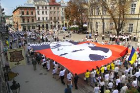 Участники шествия несут флаг с изображением Бандеры