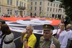 Участники шествия несут флаг с изображением Бандеры