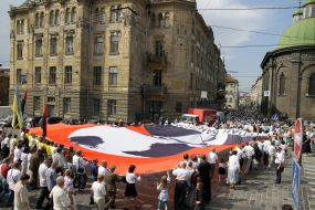 Участники шествия несут флаг с изображением Бандеры