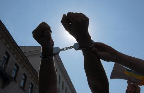 Наручники на руках участника акции