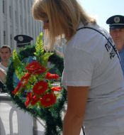 Участница акции держит венок