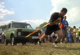 A "strongman" pulls a car