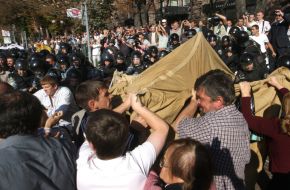 Militia employees take away tents