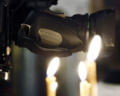 Camera lens on the background of candles