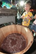 Boy near a barrel with vine juice