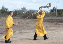 Priests carry a cross