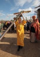 Priest lifts the cross