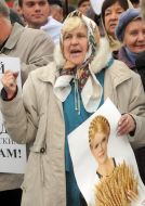 Женщина держит плакат с изображением Тимошенко