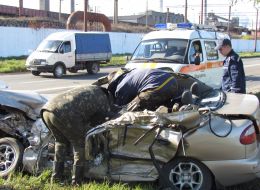 Emergency rescuers pull out the corpse of the driver's car