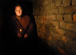 A man walks with a candle