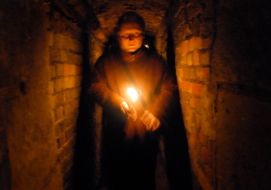 A man walks with a candle