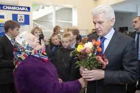 Elderly woman gives flowers to Vladimir Litvin