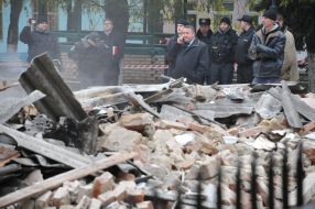 Police officers stand near the destroyed building morgue