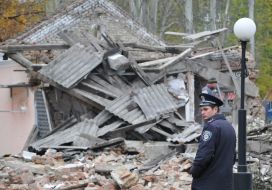 Police officer stand near the destroyed building morgue