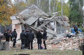 Police officers stand near the destroyed building morgue