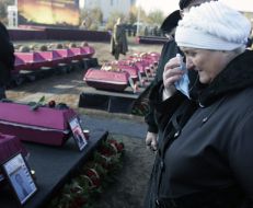 Женщина проходит возле гробов с останками бойцов Красной Армии