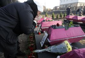 Женщина проходит возле гробов с останками бойцов Красной Армии