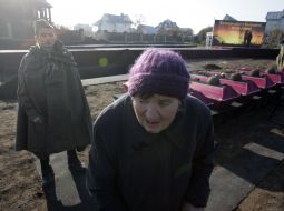 Женщина проходит возле гробов с останками бойцов Красной Армии