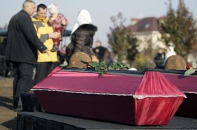 Мужчина с ребенком возле гробов с останками бойцов Красной Армии