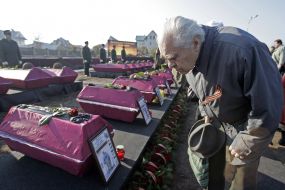 Мужчина возле гробов с останками бойцов Красной Армии