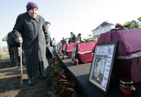 Пожилая женщина проходит возле гроба с останками Тимофея Шамрыло