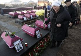 Женщина проходит возле гробов с останками бойцов Красной Армии