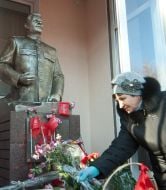 A woman lays flowers to the monument to Iosif Stalin