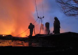 Пожарники осматривают крышу сгоревшего жилого дома