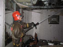 Пожарник тушит одну из квартир в жилом доме