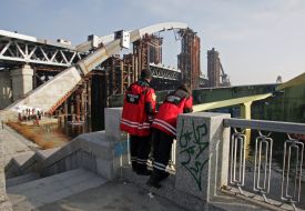 Passersby look at the fallen crane