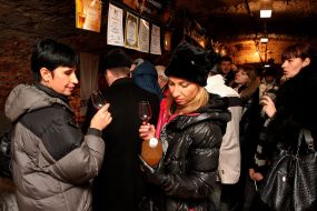 Women examine the bottle of green wine