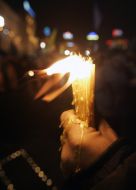 Opposition supporter holds a candle