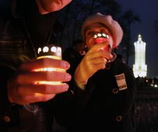 An elderly woman holds an icon lamp