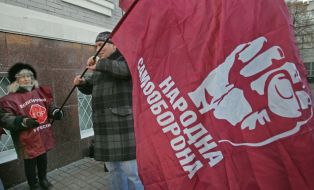 A woman holds the “Narodna samooborona” flag 