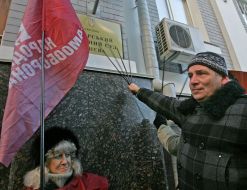 A woman holds the “Narodna samooborona” flag